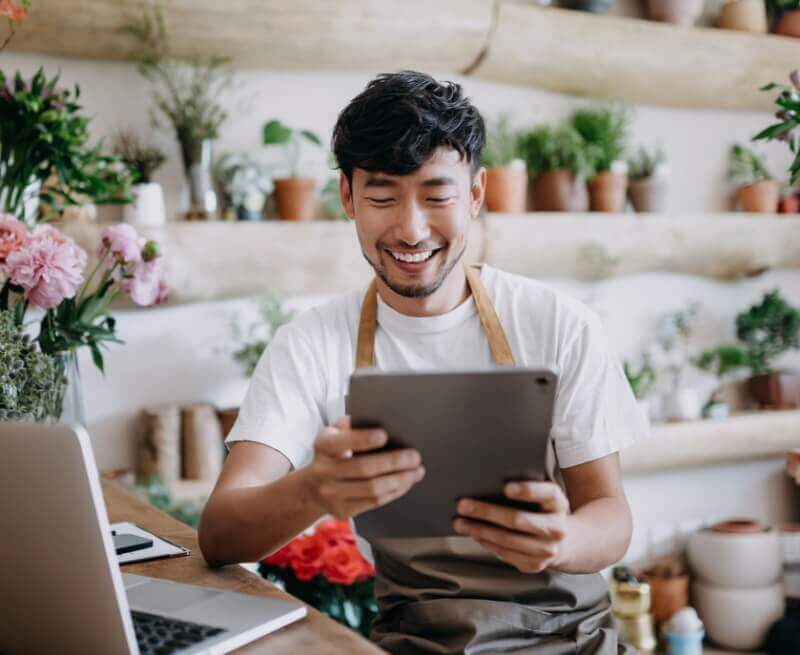 cashier holding tablet while smiling